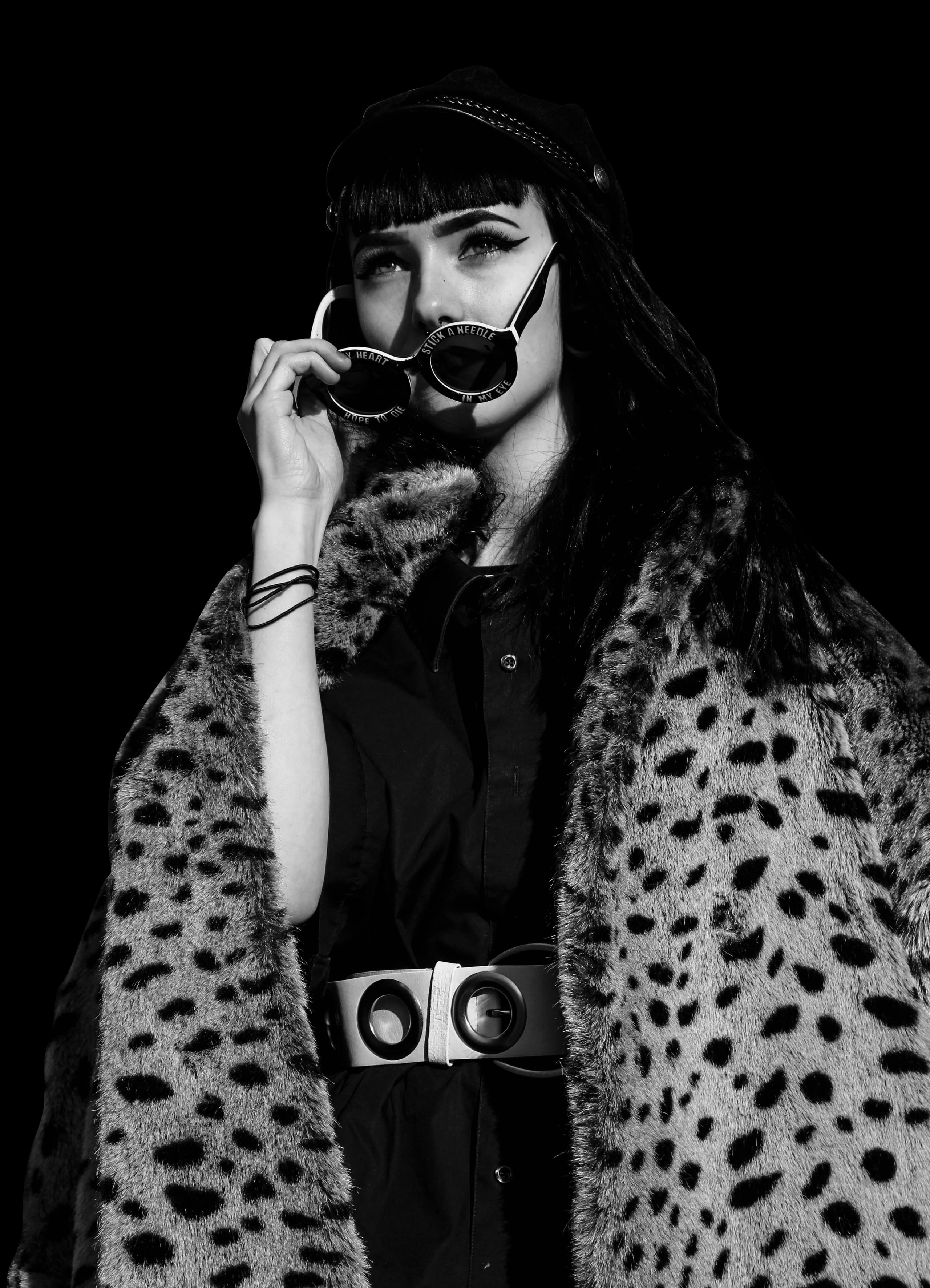 Model in a monochrome leopard-print coat and round sunglasses, urban editorial portrait