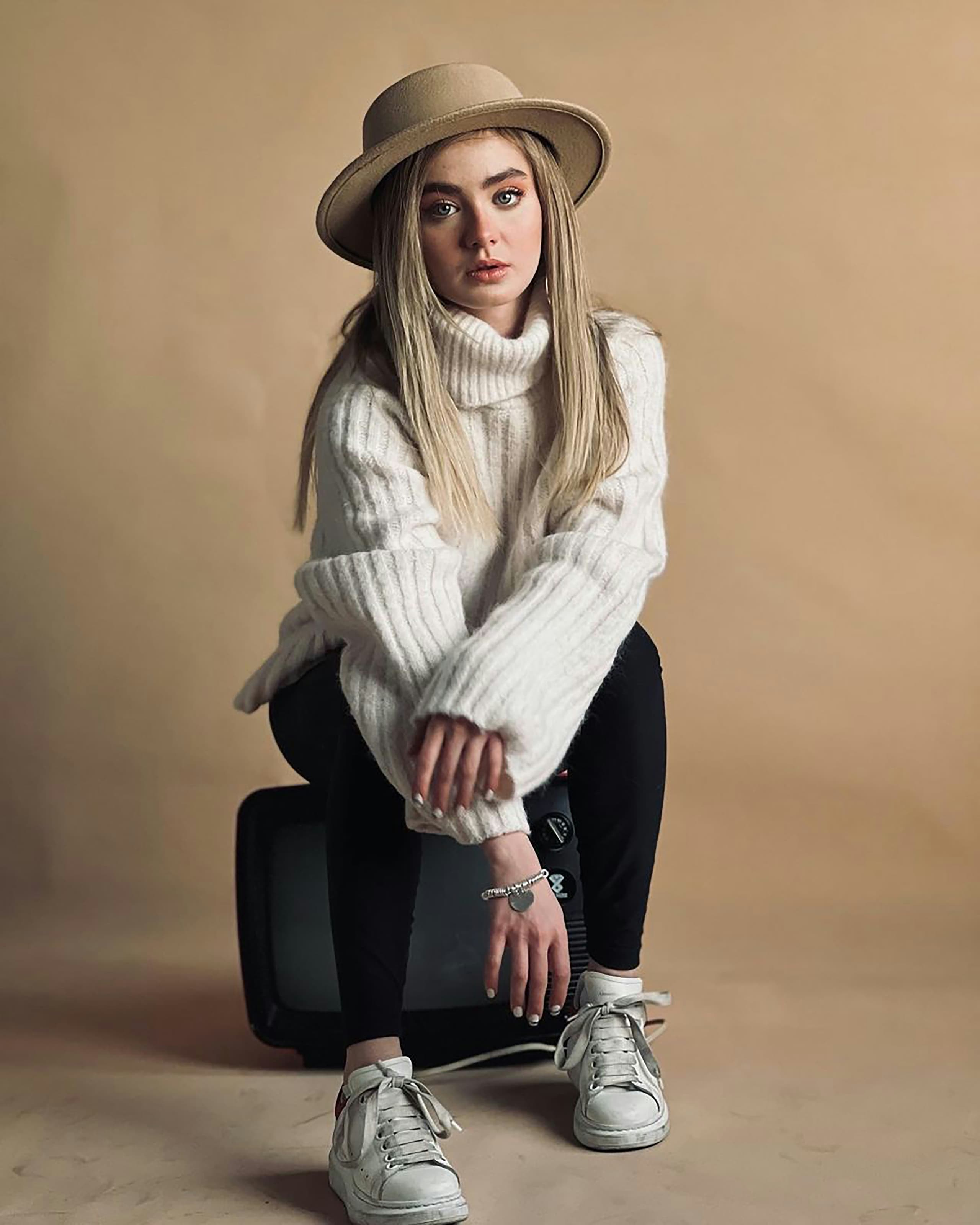Model in relaxed neutral-toned knitwear, soft natural light